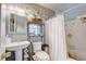 Well-lit bathroom featuring a vanity sink, toilet, and shower/tub combination with white curtain at 5501 Vance Ave, Orlando, FL 32810