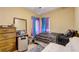 Comfortable bedroom offering a dresser, luggage, a plush chair and neutral tones at 5501 Vance Ave, Orlando, FL 32810