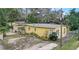 Charming single-story home with a yellow exterior, surrounded by lush landscaping at 5501 Vance Ave, Orlando, FL 32810