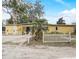 Charming single-story home with yellow exterior, white picket fence and mature trees at 5501 Vance Ave, Orlando, FL 32810
