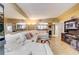 Open concept living room with a large white sectional, mirrors and eat-in kitchen views at 5501 Vance Ave, Orlando, FL 32810