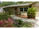 Inviting front entrance with stone accents, landscaping, and a walkway leading to a red front door at 622 Alton Rd, Winter Springs, FL 32708