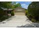 Home exterior showcasing a garage door and a long driveway, framed by trees and landscaping at 622 Alton Rd, Winter Springs, FL 32708