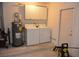 Laundry area with washer, dryer, water heater, and storage cabinets at 622 Alton Rd, Winter Springs, FL 32708