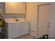 Functional laundry area with white cabinetry above washer and dryer, plus a door for convenience at 622 Alton Rd, Winter Springs, FL 32708