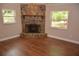 Inviting living room featuring a stone fireplace, wood-look floors, and natural light from surrounding windows at 622 Alton Rd, Winter Springs, FL 32708