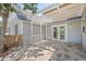Backyard patio featuring stone pavers, pergola, and access to the home through glass paneled doors at 6803 Round Lake Rd, Mount Dora, FL 32757