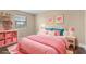 Brightly decorated bedroom with a large window, shelving, and pink accents at 6803 Round Lake Rd, Mount Dora, FL 32757
