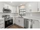 Modern kitchen features white cabinets and stainless steel appliances at 6803 Round Lake Rd, Mount Dora, FL 32757