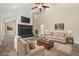 Bright living room features a fireplace, ceiling fan, and neutral-colored furniture at 6803 Round Lake Rd, Mount Dora, FL 32757