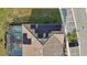 Aerial view of home with solar panels and screened pool at 7554 Oak Spring Ln, Davenport, FL 33837