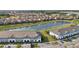 Aerial view featuring modern townhouses by a pond and well-manicured landscaping at 7554 Oak Spring Ln, Davenport, FL 33837