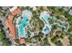 Aerial view of a community pool and lazy river with lounge seating and lush tropical landscaping at 7554 Oak Spring Ln, Davenport, FL 33837