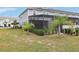 Backyard view of screened-in pool area and manicured landscaping at 7554 Oak Spring Ln, Davenport, FL 33837