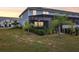 Private backyard with lush lawn, screened-in patio, and lovely palm trees and manicured hedges at 7554 Oak Spring Ln, Davenport, FL 33837