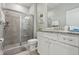 Bright bathroom with a granite countertop vanity and a glass-enclosed tiled shower at 7554 Oak Spring Ln, Davenport, FL 33837