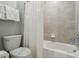 Cozy bathroom features tiled shower-tub, toilet with a paper band, and towel rack at 7554 Oak Spring Ln, Davenport, FL 33837