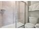 Tiled walk-in shower features glass doors in a bathroom with a white toilet at 7554 Oak Spring Ln, Davenport, FL 33837