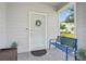 Welcoming front porch featuring neutral siding, wreath, seating, and tiled floor at 7554 Oak Spring Ln, Davenport, FL 33837