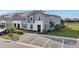 An elevated view of a multi-story townhouse showcases solar panels, parking, and water views at 7554 Oak Spring Ln, Davenport, FL 33837