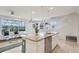 Modern kitchen with stainless steel appliances, granite countertops, and island seating area with views to the living room at 7554 Oak Spring Ln, Davenport, FL 33837