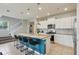 Well-lit kitchen with white cabinets, stainless steel appliances, island with seating, and stairs at 7554 Oak Spring Ln, Davenport, FL 33837