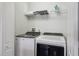 Functional laundry room with a modern washer and dryer, and convenient overhead shelving at 7554 Oak Spring Ln, Davenport, FL 33837