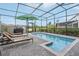 Enclosed pool area with lounge chairs and lush landscaping at 7554 Oak Spring Ln, Davenport, FL 33837