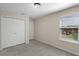 Neutral bedroom with light gray carpeting, window with blinds, and a closet at 8554 Tallfield Ave, Orlando, FL 32832