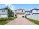 Two-story home featuring a brick driveway, an attached garage and manicured landscaping at 8554 Tallfield Ave, Orlando, FL 32832