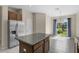 Bright kitchen with stainless steel refrigerator and island overlooking the backyard at 8554 Tallfield Ave, Orlando, FL 32832