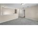 Spacious upstairs loft with neutral decor and plush gray carpeting, leading to additional rooms and storage at 8554 Tallfield Ave, Orlando, FL 32832