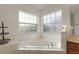 This luxurious bathroom features a large soaking tub and lots of natural light at 957 Orange Cosmos Blvd, Davenport, FL 33837