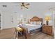 This bedroom features wood laminate flooring, a ceiling fan, and large windows providing natural light at 957 Orange Cosmos Blvd, Davenport, FL 33837
