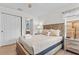 Light bedroom features a wood frame bed and a glimpse into an ensuite bathroom at 957 Orange Cosmos Blvd, Davenport, FL 33837