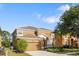 Two-story home with attached garage, manicured lawn and landscaping at 957 Orange Cosmos Blvd, Davenport, FL 33837
