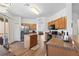 Well-lit kitchen with wooden cabinets, island, stainless steel appliances, and view to living area at 957 Orange Cosmos Blvd, Davenport, FL 33837