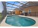 Relaxing screened-in pool and spa with view of other backyard amenities at 957 Orange Cosmos Blvd, Davenport, FL 33837