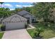 Inviting single-story home with a two-car garage and a beautifully maintained lawn with mature trees at 1003 Hart Branch Dr, Oviedo, FL 32765