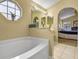 Sunken tub in the main bathroom with tile flooring and an archway leading to the bedroom at 1003 Hart Branch Dr, Oviedo, FL 32765