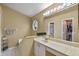 Bright bathroom with vanity, large mirror, an octagon window, and a walk-in closet at 1003 Hart Branch Dr, Oviedo, FL 32765