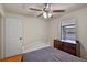 Well-lit bedroom with a dark dresser, white bedframe and ceiling fan, offering comfort and functionality at 1003 Hart Branch Dr, Oviedo, FL 32765