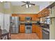 Well-lit kitchen featuring stainless steel appliances, wood cabinets, and tiled flooring at 1003 Hart Branch Dr, Oviedo, FL 32765