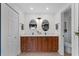 Dual sink bathroom with wooden vanity, stylish mirrors, and good lighting at 105 Dublin Dr, Lake Mary, FL 32746