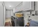 Well-organized laundry room with washer, dryer, storage cabinets, and tiled floor at 105 Dublin Dr, Lake Mary, FL 32746