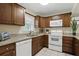 Functional kitchen with wood cabinets, white appliances, and a window overlooking the yard at 1136 Villa Ln # 96, Apopka, FL 32712