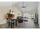 Open-concept living room featuring vaulted ceilings, a ceiling fan, and sliding doors to the lanai at 1136 Villa Ln # 96, Apopka, FL 32712