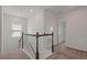Hallway with carpet flooring and wooden and white railing with an open door at the end at 1151 Wildmeadow Run, Winter Park, FL 32792