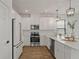 Well-lit kitchen features stainless appliances, white cabinets, modern lighting, and wood-look flooring at 1151 Wildmeadow Run, Winter Park, FL 32792