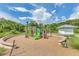 Community playground featuring modern climbing structures and a soft landing area surrounded by natural landscaping at 1151 Wildmeadow Run, Winter Park, FL 32792